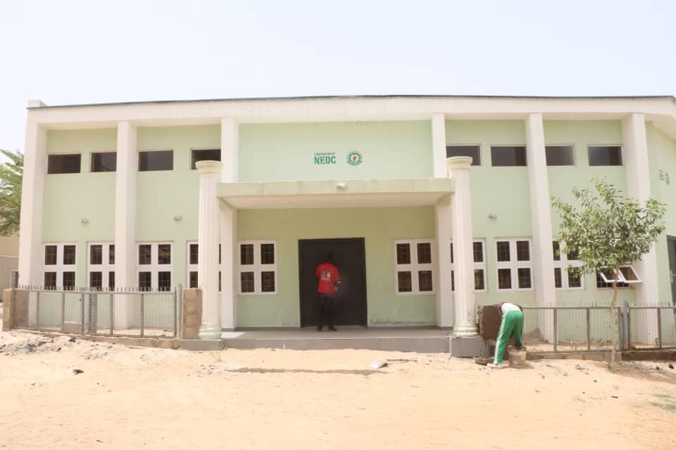 Exterior of a newly constructed two-storey school building with NEDC branding
